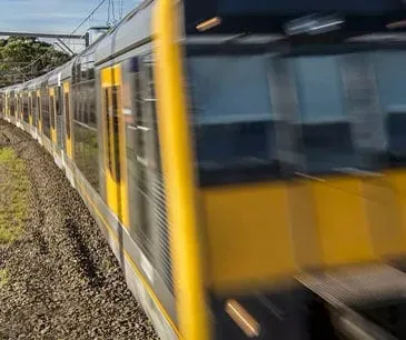 Passenger train passing at speed on a suburban railway line