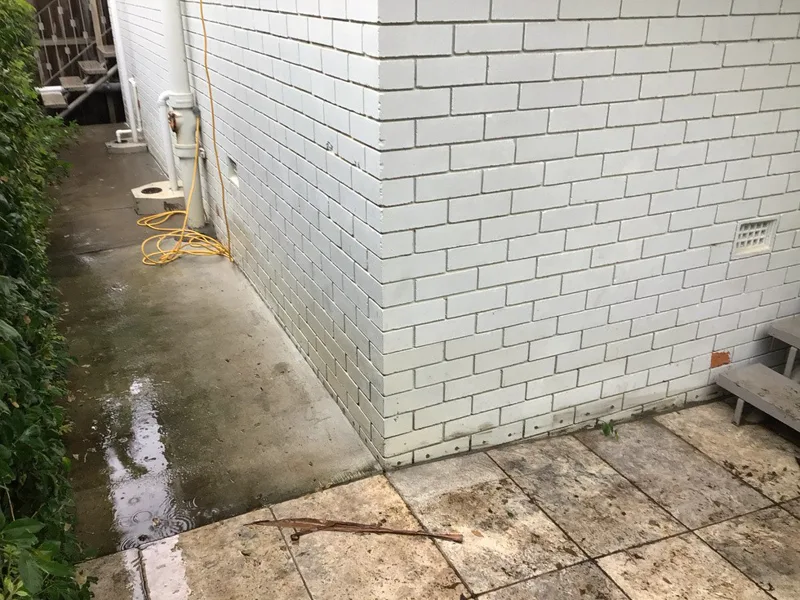 Exterior corner of Ashgrove unit building showing damp staining at base of brickwork