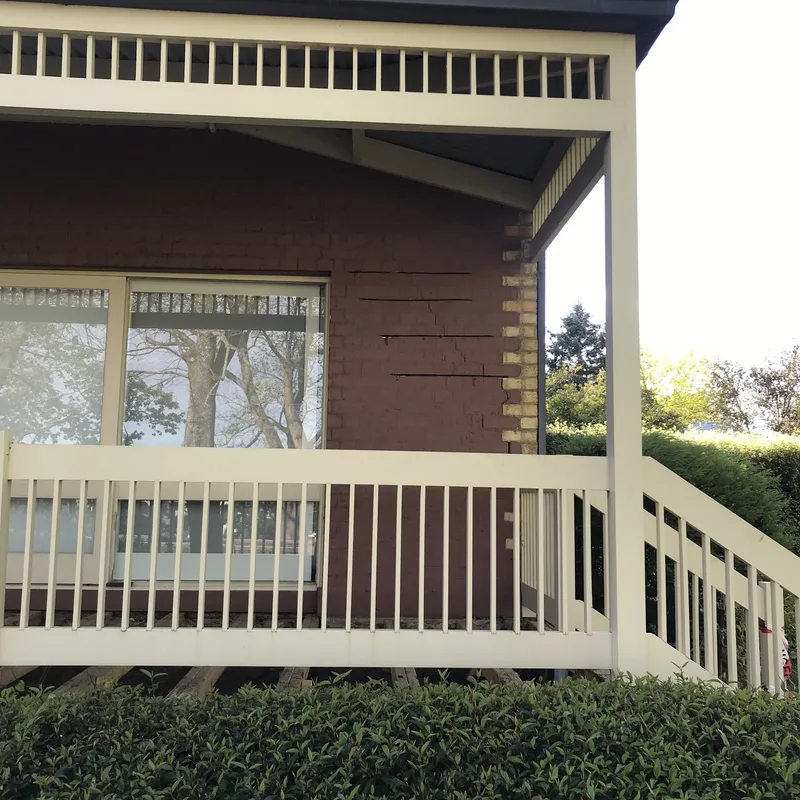 Cream timber verandah and red brick of the finished Berwick cottage after foundation stabilisation and wall crack repair
