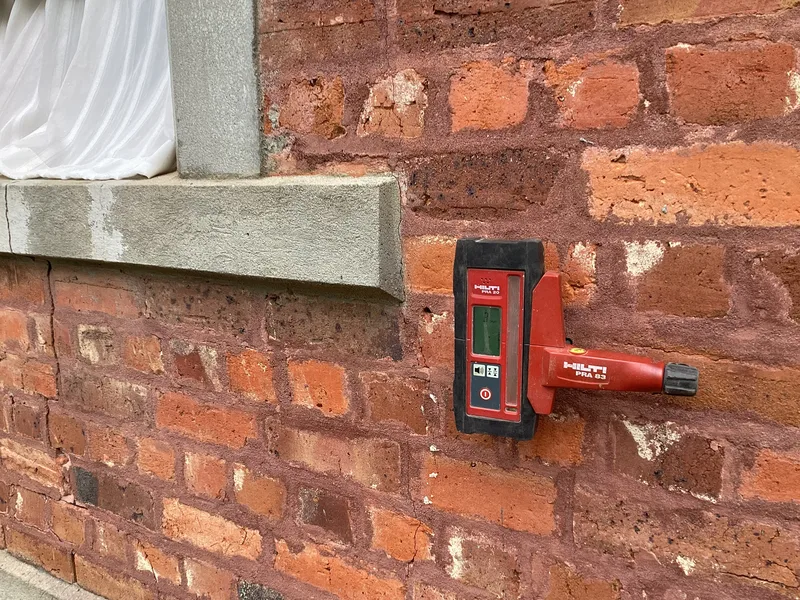 Hilti laser receiver mounted on the heritage brickwork to monitor the lift during foundation repair in Berwick