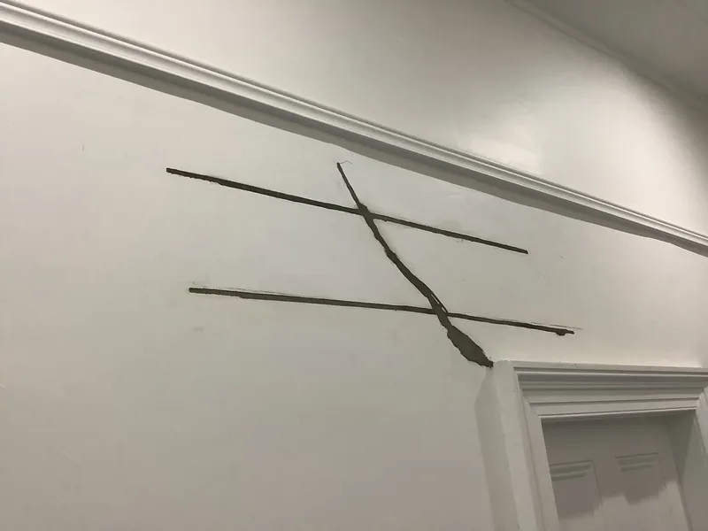 Diagonal crack above a doorway with 2 HelicalBar™ slots grouted across it during wall crack repair in Berwick