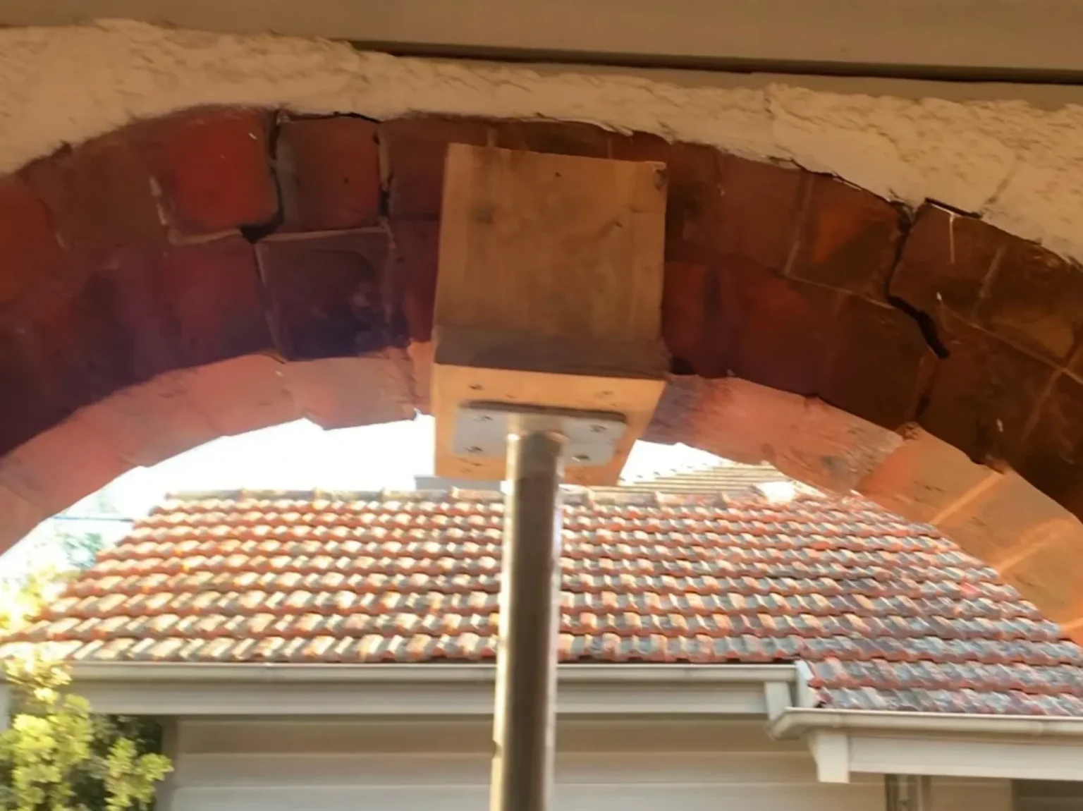 Temporary support post stabilising cracked brick arch during structural foundation repair.
