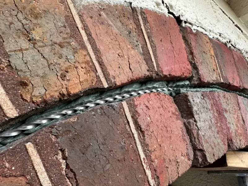 HelicalBar reinforcing cracked brick wall for foundation repair and structural support