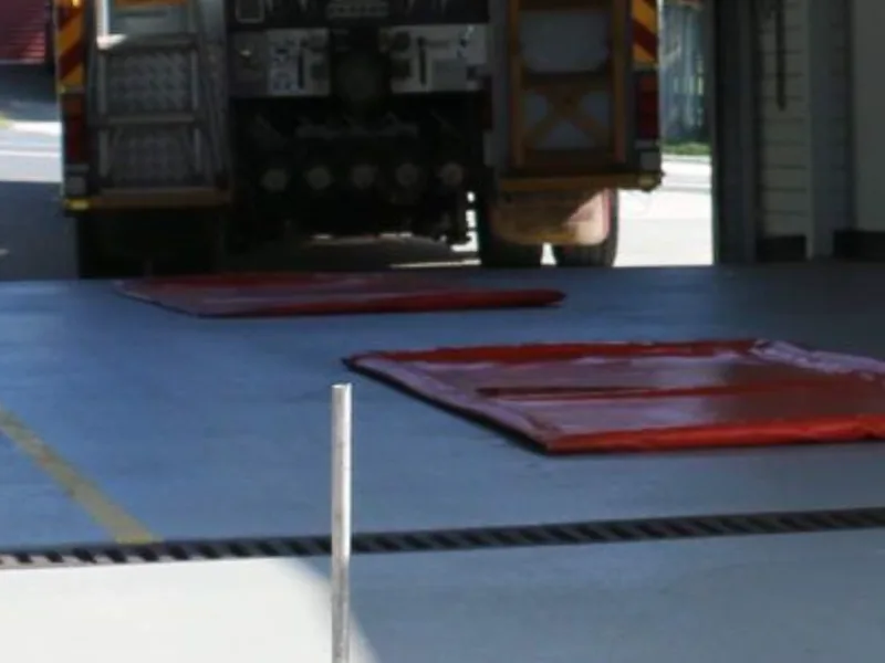 Sealed injection holes and a laser rod on the relevelled Camp Hill Fire Station driveway slab, fire truck in the bay