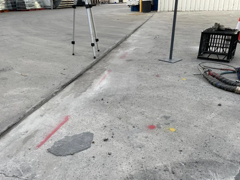 The sunken slab joint at Rylock, Dingley Village, with injection points marked in red, the laser tripod set up and the GeoPoly™ hose laid out