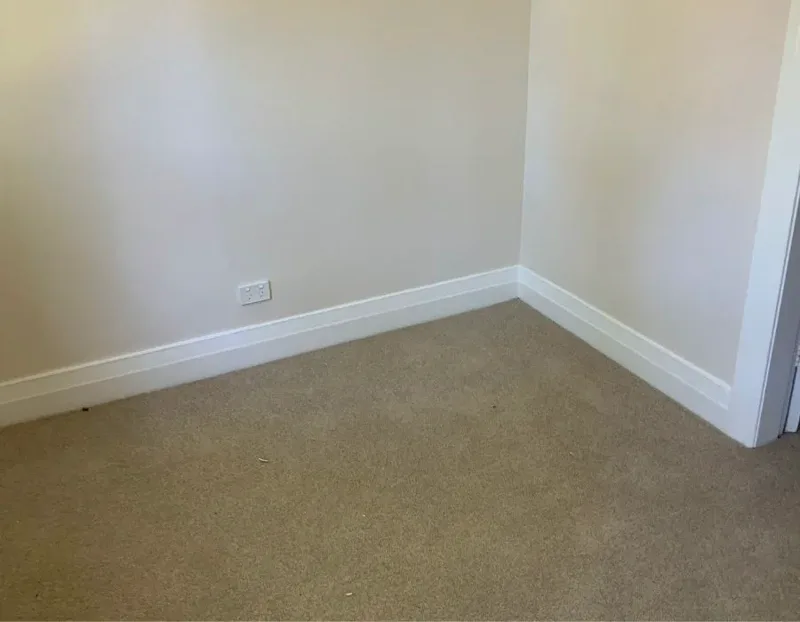The lower-floor room of the Turramurra semi after rising damp treatment, walls dry and painted with new skirting boards fitted