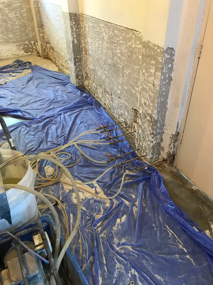 DampBlock injection hoses connected to stripped internal walls at Frenchs Forest home