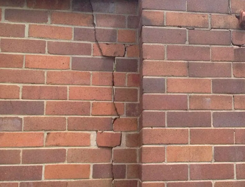 Stepped crack running through heritage brickwork at a pier junction showing structural movement