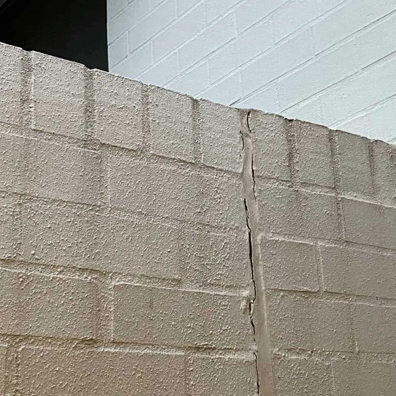 Vertical crack through the rendered block boundary wall at the Newington apartment block before it was lifted and stabilised