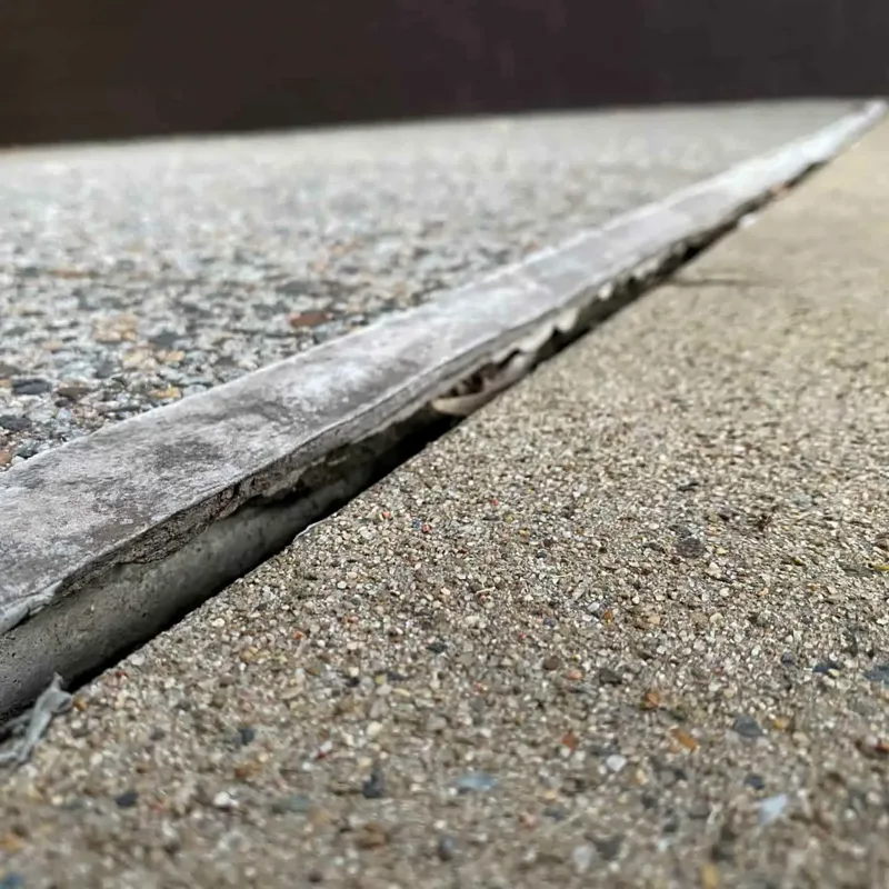 Dropped paving slab edge outside the Newington apartment block with the lip it had sunk to before GeoPoly™ was injected