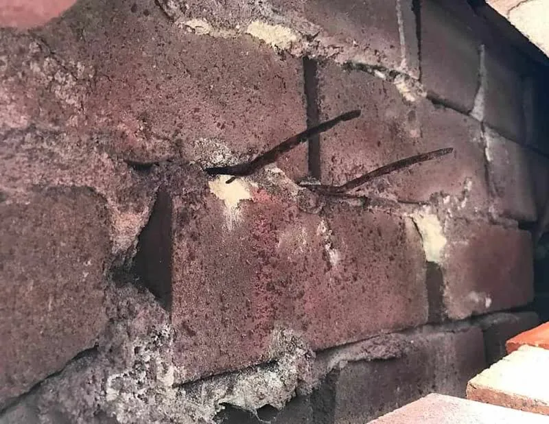 Corroded mild steel wall ties exposed inside cavity wall of coastal Manly home