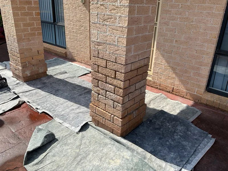 Both balcony pillars at Prestons home showing rising damp damage with protective sheeting laid out