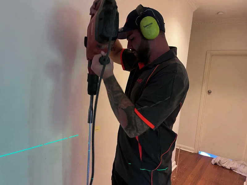 Buildfix technician drilling from above with laser level monitoring