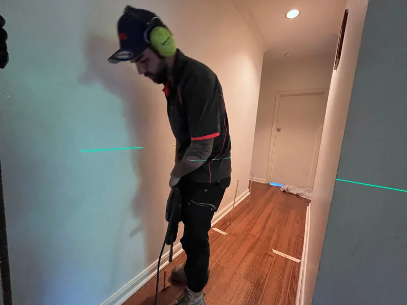 Technician injecting GeoPoly™ through floor with precision laser guidance