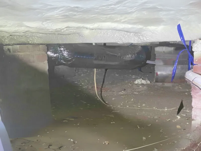 Crawl space beneath weatherboard home showing destabilised piers and plumbing