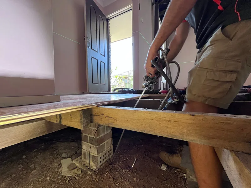 Technician injecting GeoPoly™ through floor with laser level monitoring