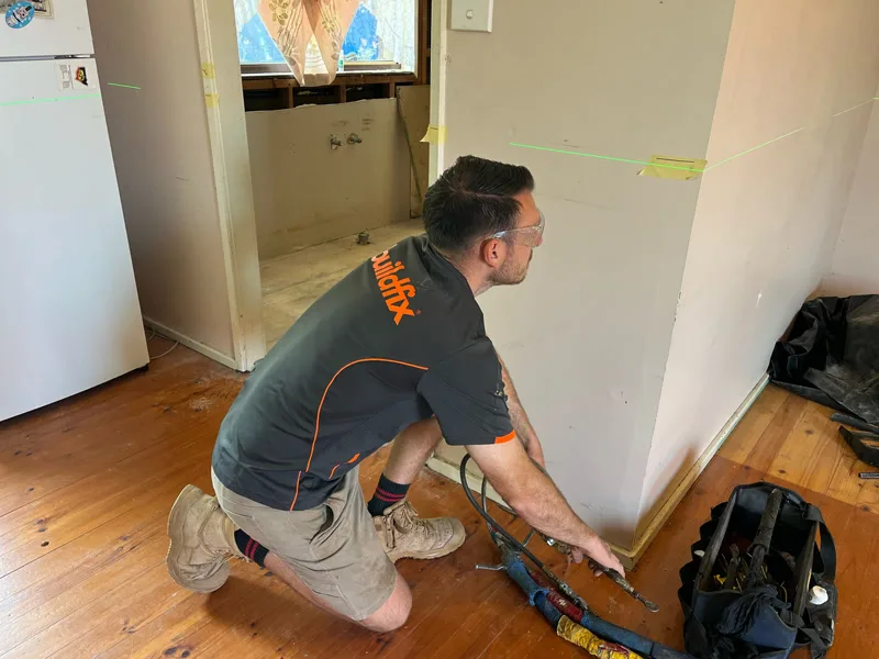 Buildfix technician completing pier stabilisation at skirting level