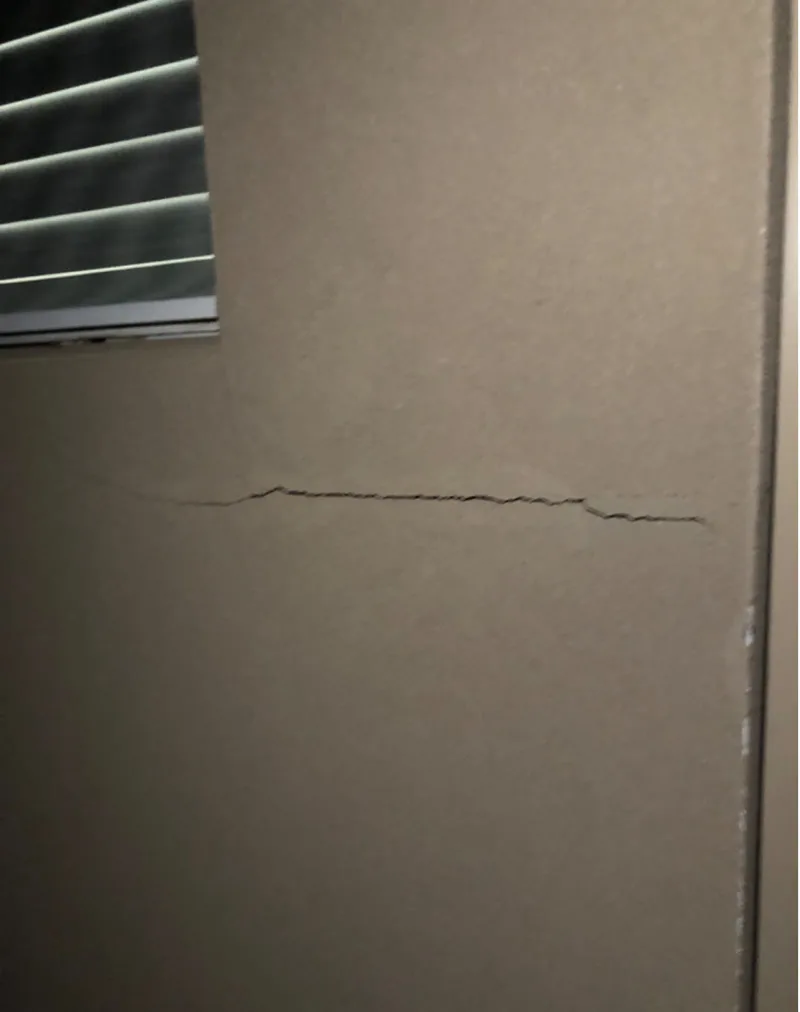 Hairline wall crack below window in Southport investment property