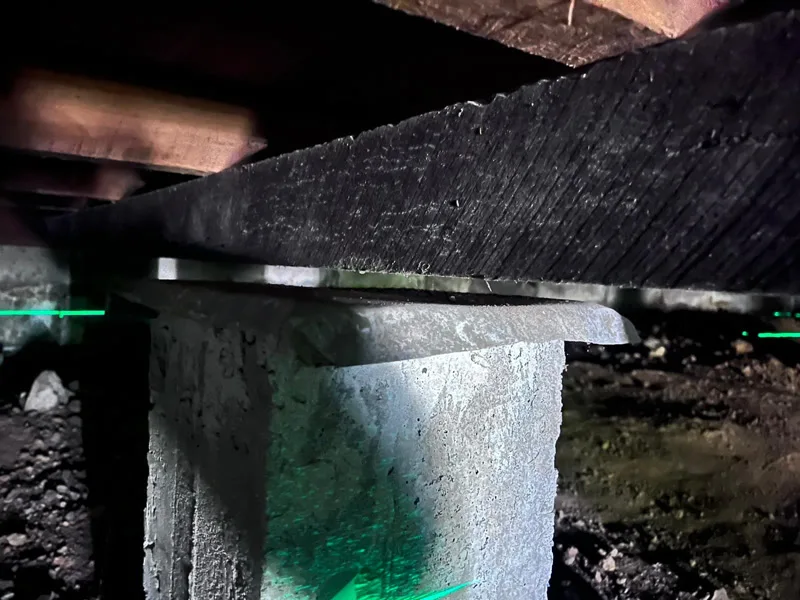 Stump and bearer gap with laser level showing settlement