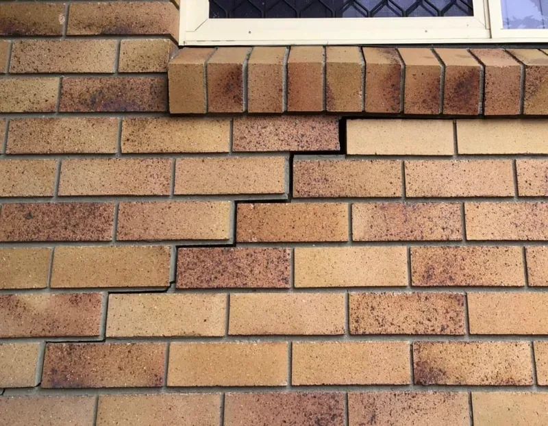 Stepped crack following the mortar joints beneath a window in the brick veneer of the Brisbane bungalow