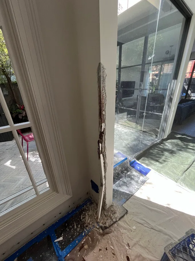 Terrace wall column at Stanmore home with exposed damaged plaster from rising damp