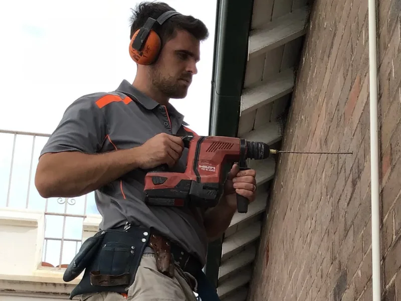 Buildfix technician drilling HelicalBar T316 bow-fix wall ties into Strathfield heritage brickwork