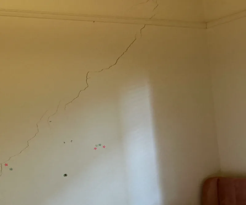 Diagonal crack on bedroom wall above child’s bed in Windsor Victorian home