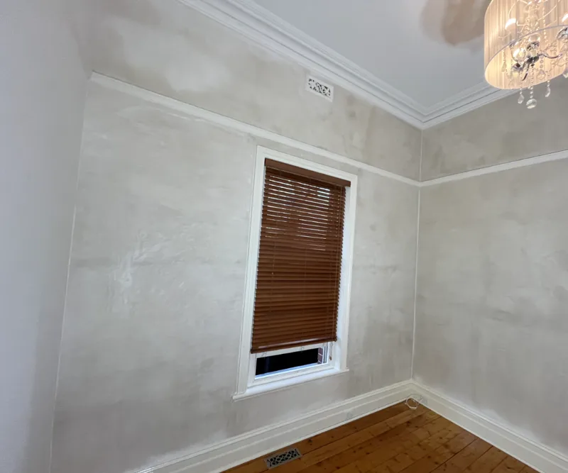 Finished bedroom with smooth gypsum plaster walls left paint-ready after structural repair