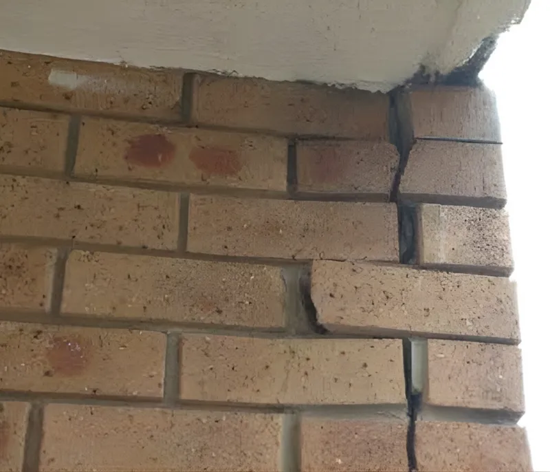 Vertical crack at brick wall corner where bricks are expanding and pushing apart at the soffit line