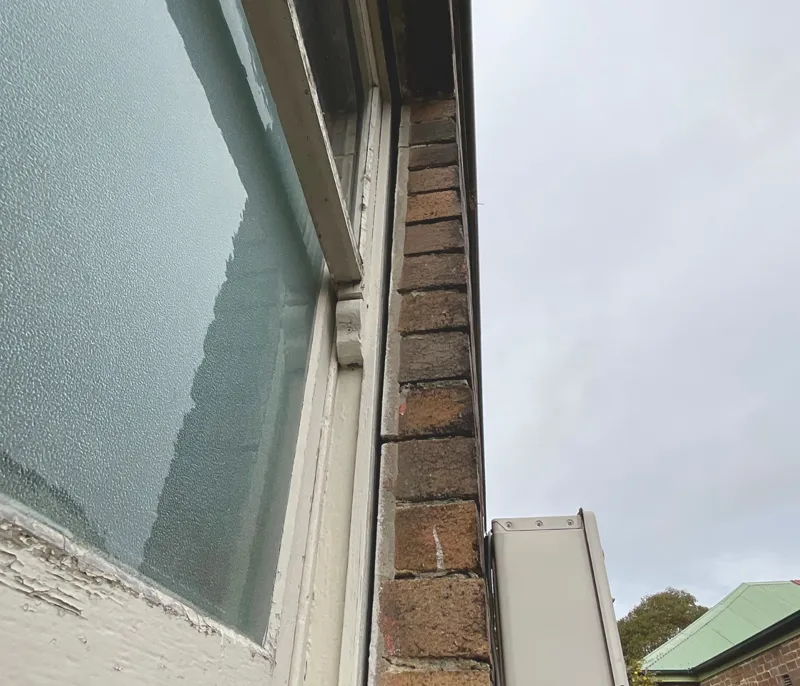 Brickwork separating from window frame and roofline with visible gap widening over time