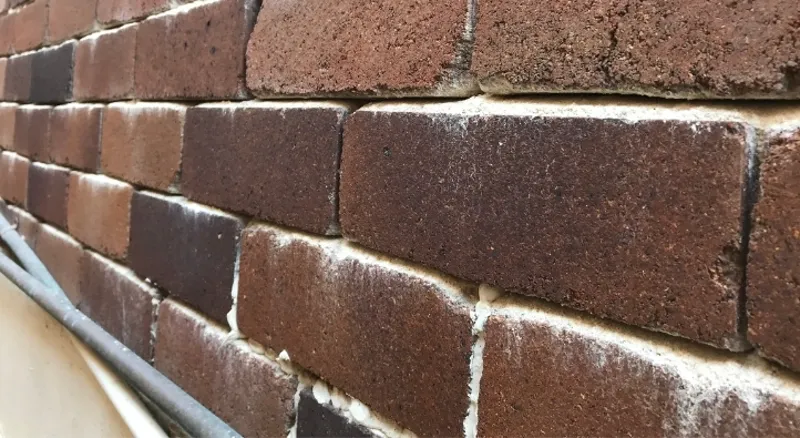 Deteriorated mortar joints between bricks crumbling and receding from salt crystallisation damage