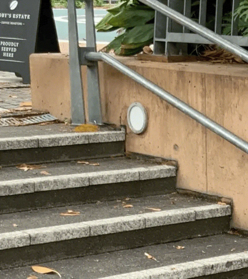 Sunken granite stairs near café with uneven step edges
