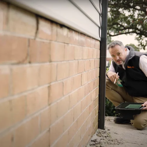 Buildfix structural engineer assessing sunken concrete slab with laser level equipment
