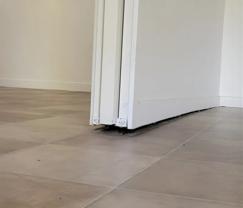 Gap under base of internal wall where floor has dropped away from skirting board