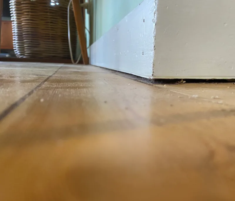 Floor-level view showing visible slope between floor and skirting board