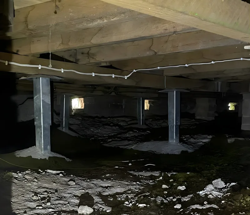 Old brick pier being removed and replaced with new concrete pier beneath a subfloor