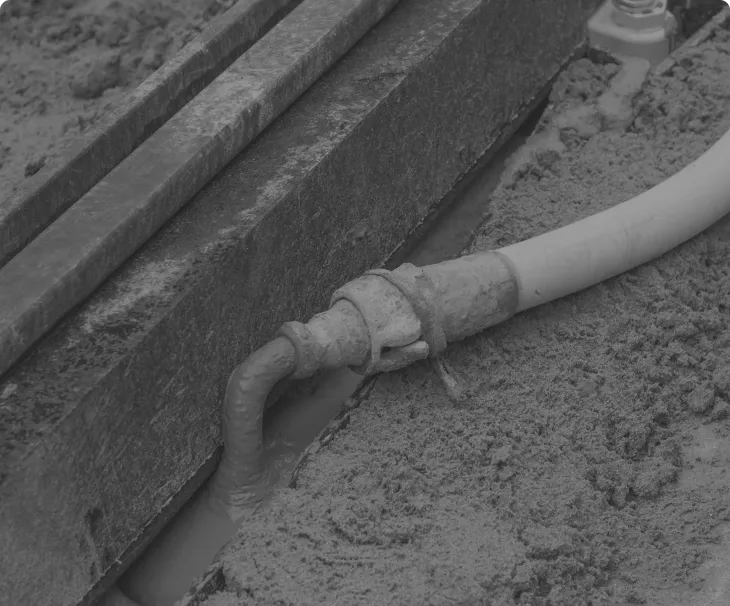 Cement grout being pumped beneath a structure to fill voids