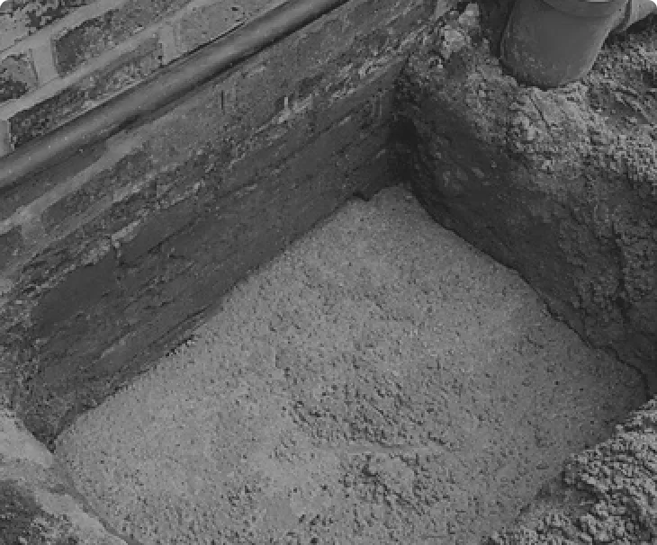 Trenches dug beside brick wall footings for mass concrete underpinning