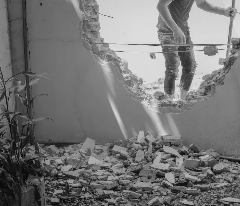 Demolished brick wall with rubble on the ground during knock down and rebuild