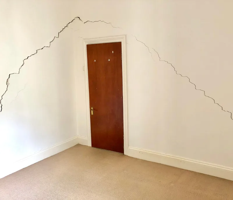 Diagonal cracks running across internal walls around a door frame caused by differential subsidence