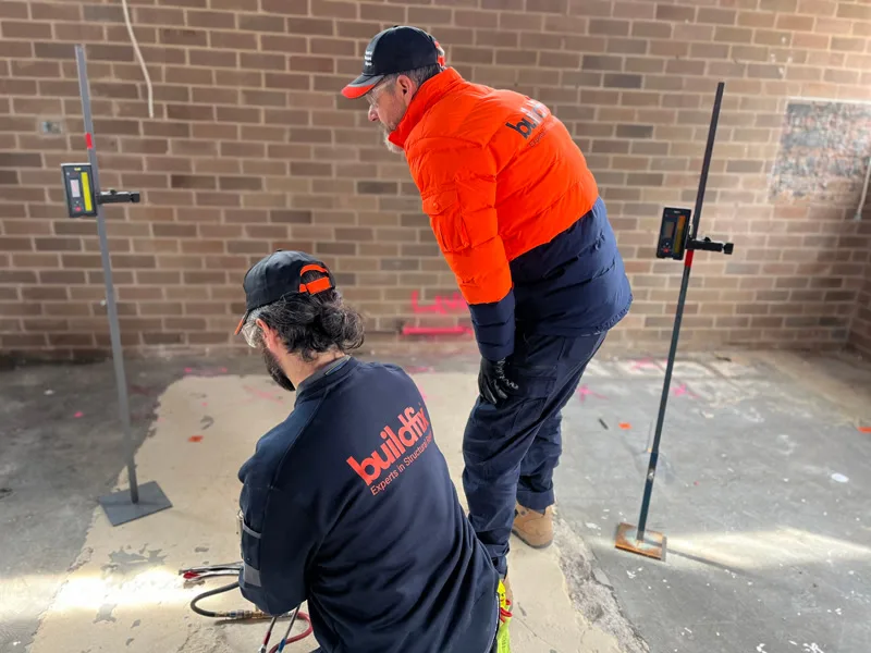 Two Buildfix workers with laser levels monitoring floor injection