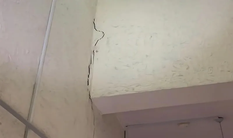 Interior wall crack running along plaster near ceiling