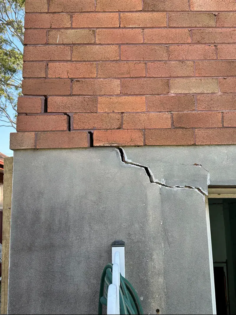 Staircase crack in brick and render wall