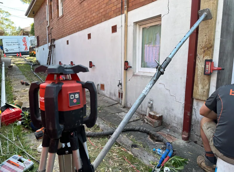 Buildfix setup with laser level, injection pole and cracked wall
