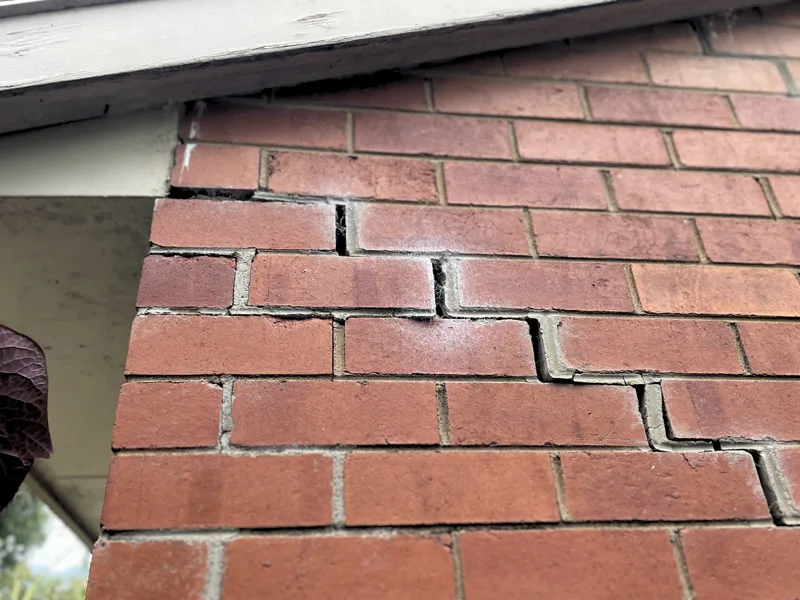 Brick wall near eaves showing staircase crack