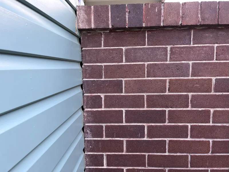Same brick pier-weatherboard gap closed after repair