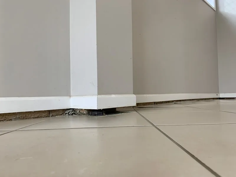 Floor-level view showing gap between skirting and tiles