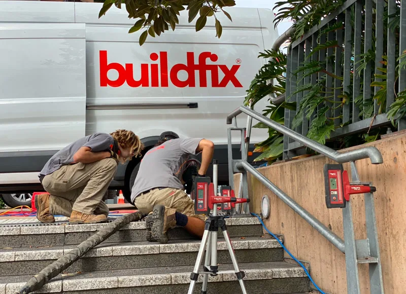 Buildfix crew working on granite stairs with laser levels