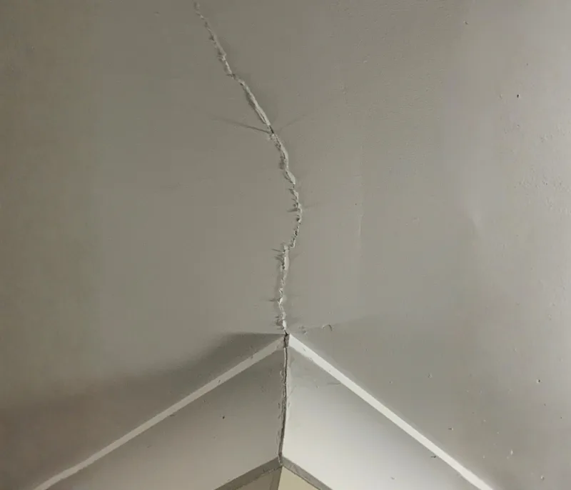 Ceiling crack running through cornice corner caused by concrete slab movement