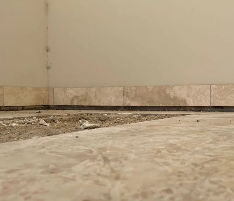 Cracked and popping floor tiles caused by uneven concrete slab movement